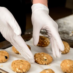 close up photo hands puting tasty cookies baking tray